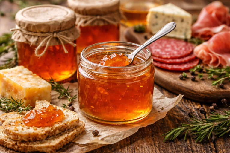 Jars of savoury Wexford crab apple jelly with a clear amber colour, shown set and ready to serve with meats or cheese.